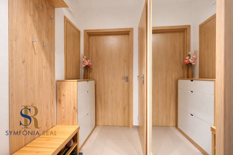 Oslnutý predsieň s drevenými dverami.png