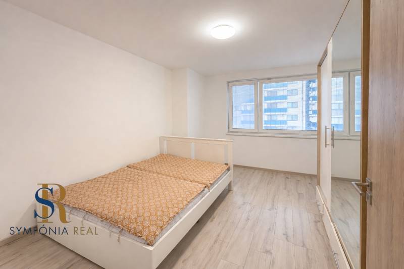 Minimalist spálňa s oranžovou posteľou.png